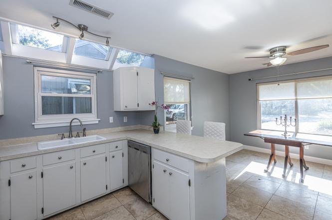 Kitchen before renovation: white cabinets, gray walls, dated tile